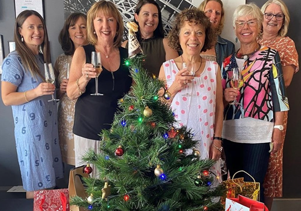 group of women in front of christmas tree